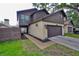 Two story home with a dark brown garage door, beige walls, and dark brown siding at 13703 Sweetwater Cove Pl, Tampa, FL 33613