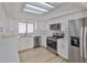 A bright kitchen with stainless appliances, white cabinets, skylight, and wood-look flooring at 13703 Sweetwater Cove Pl, Tampa, FL 33613