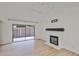 Bright living room with a modern fireplace, sleek floors, and sliding doors to the backyard at 13703 Sweetwater Cove Pl, Tampa, FL 33613