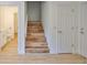 An interior stairway featuring vinyl plank steps and white walls at 13703 Sweetwater Cove Pl, Tampa, FL 33613