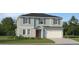 Charming two-story home with a well-manicured lawn and attached garage, offers delightful curb appeal at 15042 Zircon Red Dr, Wimauma, FL 33598
