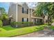 Inviting home with lush green lawn, mature trees, black shutters, and a charming red front door at 16504 Lake Brigadoon Cir, Tampa, FL 33618