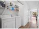 Bright laundry room features modern washer and dryer with shelving and storage space for convenience at 16504 Lake Brigadoon Cir, Tampa, FL 33618