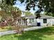 Charming single-story home featuring a well-maintained lawn and a beautiful flowering tree at 1910 New Hampshire Ne Ave, St Petersburg, FL 33703