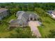 Stunning aerial view of the estate home featuring a circular brick driveway, lush landscaping, and mature trees at 19815 Sea Rider Way, Lutz, FL 33559