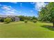 Expansive backyard with a manicured green lawn, screened-in enclosure, and winding brick path amid mature trees at 19815 Sea Rider Way, Lutz, FL 33559