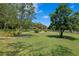 Vast backyard with a winding brick path, mature trees, and well-maintained landscaping providing a serene outdoor space at 19815 Sea Rider Way, Lutz, FL 33559