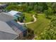 Aerial shot of backyard featuring a winding brick pathway and manicured greenery, leading to a screened-in pool area at 19815 Sea Rider Way, Lutz, FL 33559