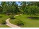 Image showing backyard brick path with manicured shrubs and flowers leading to a secluded area at 19815 Sea Rider Way, Lutz, FL 33559