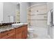 Well-lit bathroom featuring a tub-shower combination with patterned tile surround and a vanity with a granite countertop at 19815 Sea Rider Way, Lutz, FL 33559