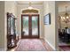 Grand foyer with decorative glass double doors, wood floors, and elegant chandelier at 19815 Sea Rider Way, Lutz, FL 33559