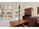 Well-lit home office with built-in shelves, wooden desk, and comfortable chair at 19815 Sea Rider Way, Lutz, FL 33559