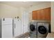 Functional laundry room with a washer, dryer, refrigerator, and storage cabinets at 19815 Sea Rider Way, Lutz, FL 33559