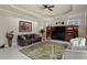 Cozy living room with leather sofa, decorative rug, and entertainment center with built-in shelving at 19815 Sea Rider Way, Lutz, FL 33559