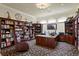 Home office with custom built-in bookshelves, desk, and comfortable seating area at 19815 Sea Rider Way, Lutz, FL 33559