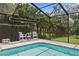 Screened-in pool has an awning, and lots of seating with a beautiful green backdrop at 19815 Sea Rider Way, Lutz, FL 33559