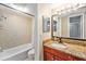 Bathroom showcasing a granite-topped vanity with updated fixtures and tiled shower over tub at 200 Country Club Dr # 403, Largo, FL 33771
