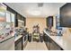 Compact kitchen with dark cabinetry, tile floors, and essential appliances under recessed lighting at 200 Country Club Dr # 403, Largo, FL 33771