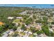 Aerial view of a waterfront neighborhood with green trees and a view of the ocean at 2004 Yale Ave, Dunedin, FL 34698