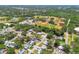 Neighborhood aerial view with a baseball field, pond, and a mix of residential homes at 2004 Yale Ave, Dunedin, FL 34698