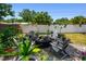 Backyard fire pit area with Adirondack chairs surrounded by lush landscaping, perfect for outdoor relaxation at 2004 Yale Ave, Dunedin, FL 34698