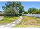 Lush backyard featuring a meandering stone path, expansive lawn, and privacy fence, perfect for outdoor enjoyment at 2004 Yale Ave, Dunedin, FL 34698