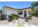 Charming backyard with stone pathway, lush greenery, and a cozy outdoor dining area with a grill at 2004 Yale Ave, Dunedin, FL 34698