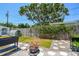 Private backyard with a wooden fence, stepping stone pathway, and mature trees at 2004 Yale Ave, Dunedin, FL 34698