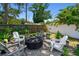 Landscaped backyard featuring a fire pit with Adirondack chairs, creating a cozy outdoor gathering space at 2004 Yale Ave, Dunedin, FL 34698