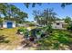 Expansive backyard featuring mature trees, a stone pathway, a shed, and comfortable seating for outdoor gatherings at 2004 Yale Ave, Dunedin, FL 34698