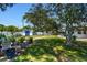 Well-landscaped backyard with mature trees, a garden shed, and a stone pathway for a serene outdoor experience at 2004 Yale Ave, Dunedin, FL 34698