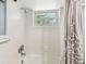 Bright bathroom features a tiled shower and tub combination with a window at 2004 Yale Ave, Dunedin, FL 34698