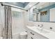 Bathroom featuring a large mirror, a shower-tub combo, and white fixtures at 2004 Yale Ave, Dunedin, FL 34698