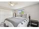 Neutral bedroom with a ceiling fan, large windows, closet, and dark wood furnishings at 2004 Yale Ave, Dunedin, FL 34698