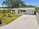 Charming single-story home with manicured lawn, brick driveway, and mature landscaping in a desirable neighborhood at 2004 Yale Ave, Dunedin, FL 34698