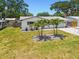 Well-kept single-Gathering home featuring a lush lawn, mature palm trees, and brick driveway at 2004 Yale Ave, Dunedin, FL 34698