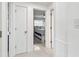Hallway with bedroom view featuring terrazzo floors, neutral walls, and a bedroom with a ceiling fan at 2004 Yale Ave, Dunedin, FL 34698