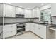 Updated kitchen with stainless steel appliances, including a double oven and microwave, and bright white cabinets at 2004 Yale Ave, Dunedin, FL 34698