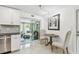 Bright kitchen featuring a dining area, stainless steel appliances, and a sliding glass door to the sunroom at 2004 Yale Ave, Dunedin, FL 34698