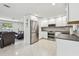 Spacious kitchen with stainless steel appliances, bright white cabinetry, and views into the living room at 2004 Yale Ave, Dunedin, FL 34698
