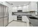 Modern kitchen with stainless steel appliances, double oven, white cabinets, and light grey backsplash at 2004 Yale Ave, Dunedin, FL 34698
