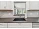 Close-up of the kitchen sink area with updated faucet, lighting, and stainless steel appliances at 2004 Yale Ave, Dunedin, FL 34698