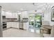 Bright kitchen features white cabinets, stainless steel appliances, and a view into the dining area with a chandelier at 2004 Yale Ave, Dunedin, FL 34698