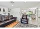 Spacious living room with comfortable leather seating and a view into a modern kitchen and dining area at 2004 Yale Ave, Dunedin, FL 34698