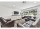 Comfortable living room features a console table, large windows, modern sofas, and neutral decor at 2004 Yale Ave, Dunedin, FL 34698