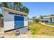 Backyard shed featuring double doors, positioned beside a greenhouse and overlooking a stone pathway at 2004 Yale Ave, Dunedin, FL 34698