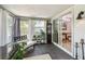 Sunroom featuring backyard views, a contemporary bench, decorative shelving, and access to the dining room at 2004 Yale Ave, Dunedin, FL 34698