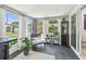 Bright sunroom with tile floors, backyard views, contemporary furniture, and decorative shelving at 2004 Yale Ave, Dunedin, FL 34698