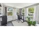 Bright sunroom featuring a black desk, tile flooring, and large windows with backyard views at 2004 Yale Ave, Dunedin, FL 34698