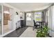 Bright sunroom featuring an office desk, tile flooring, backyard views, and access to the kitchen at 2004 Yale Ave, Dunedin, FL 34698